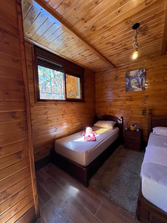 a room with two beds in a wooden cabin at Hôtel nabil akchour in Akchour