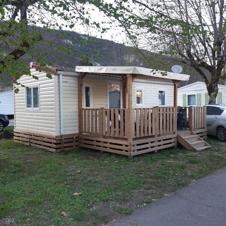 a small house with a porch and a deck at camping sous le moulin in Condes