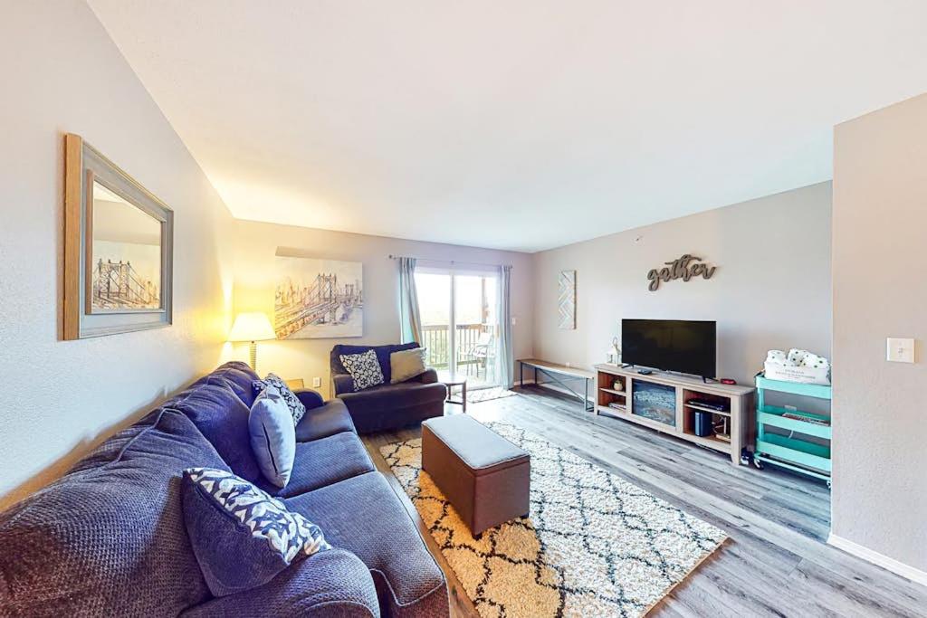 a living room with a blue couch and a tv at Vineyards 2909 #3 in Branson