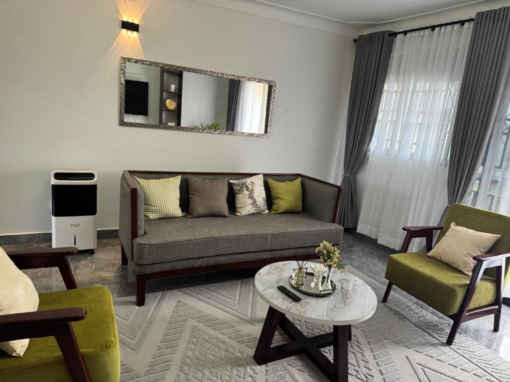 a living room with a couch and two chairs and a table at Elp Living in Hoima