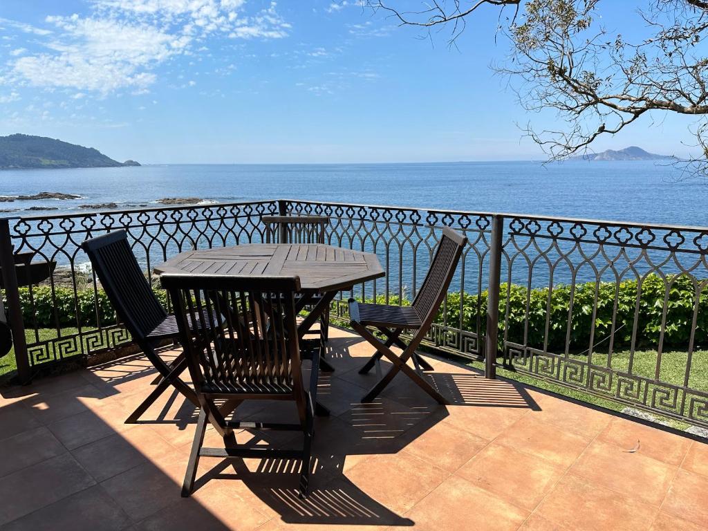a table and chairs on a balcony overlooking the ocean at Casas sobre el mar en Vigo in Vigo