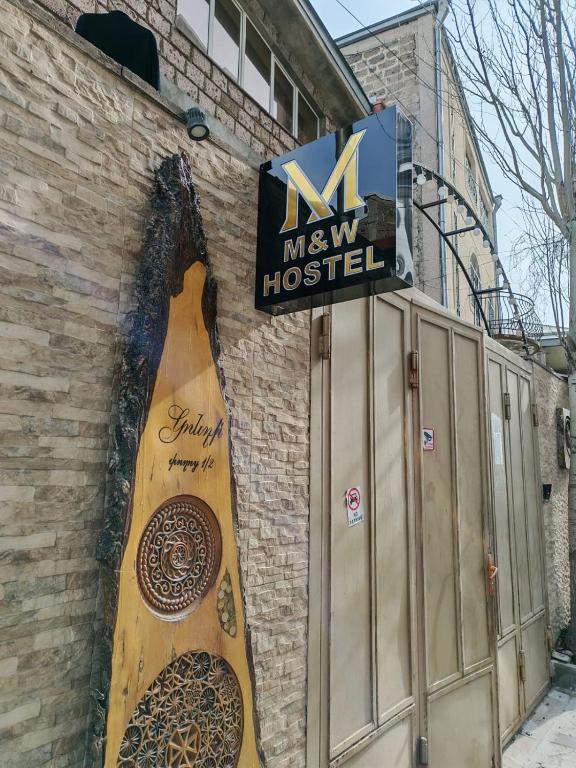 a store with a large wooden guitar on the side of a building at M&W Hostel in Yerevan