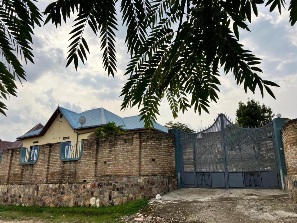 a house with a fence and a brick wall at Bonnie's Homestay 