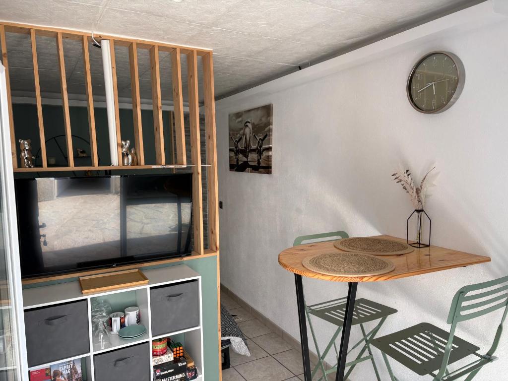 a room with a table and a clock on a wall at Coconning studio in Plauzat