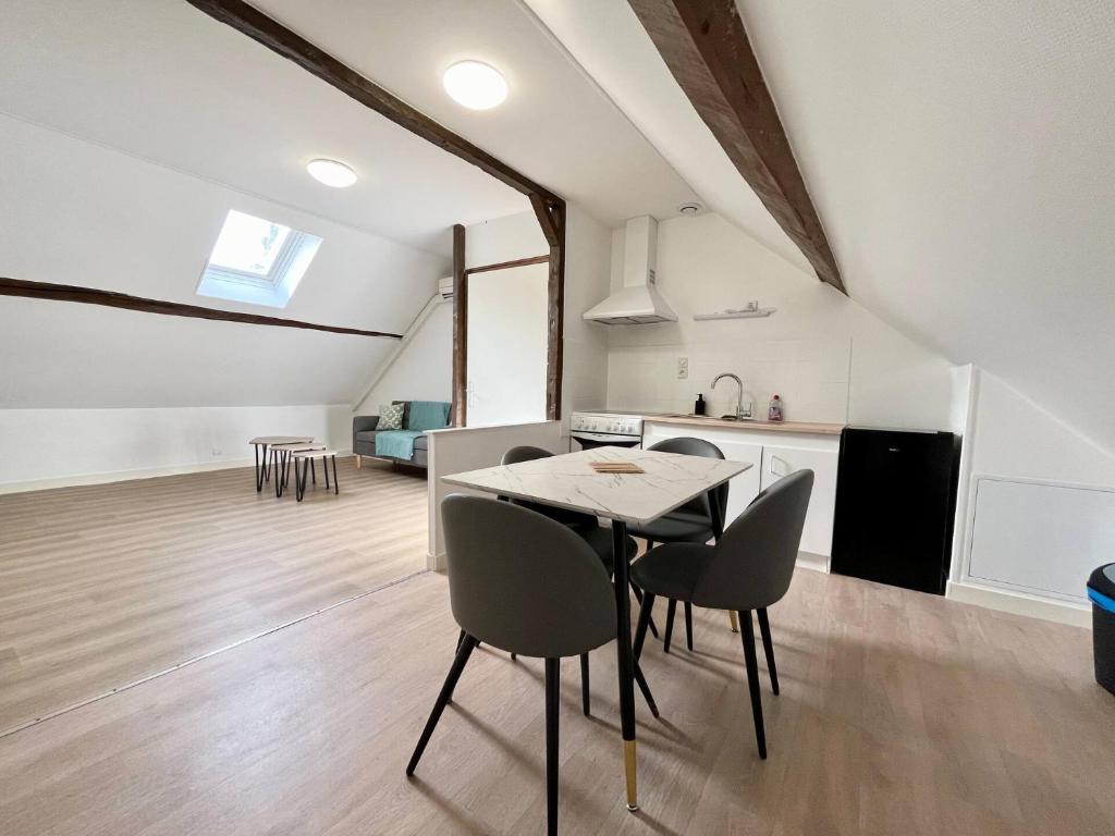 a kitchen and dining room with a table and chairs at Le refuge des Ormes in Les Ormes