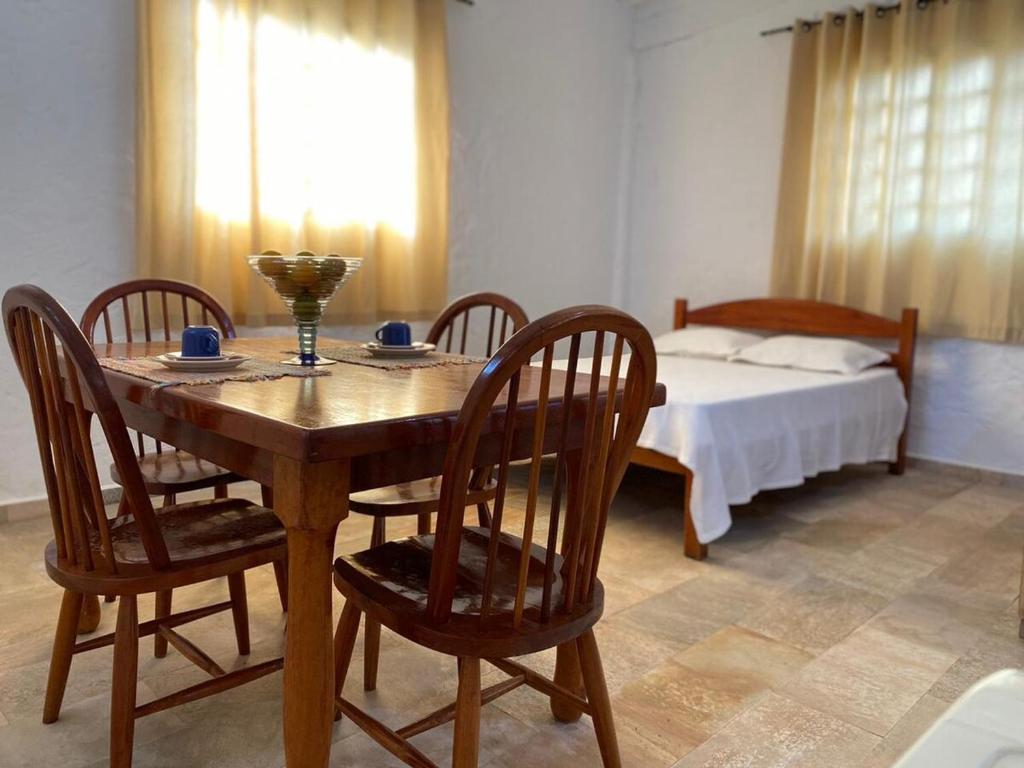a dining room with a table and chairs with a bed at Loft no Sul de Minas in Baependi