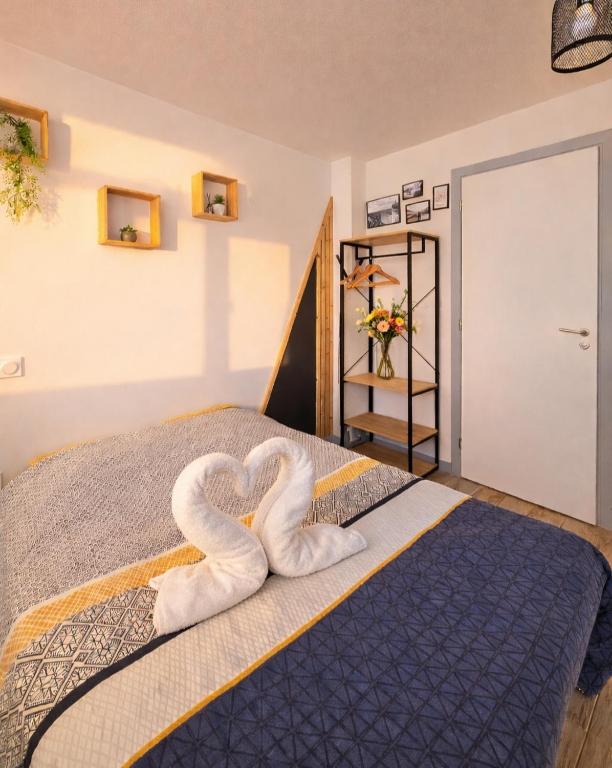 a bed with two towels in the shape of hearts at Chez Coco - Studio à 200m de la Gare ! in Besançon