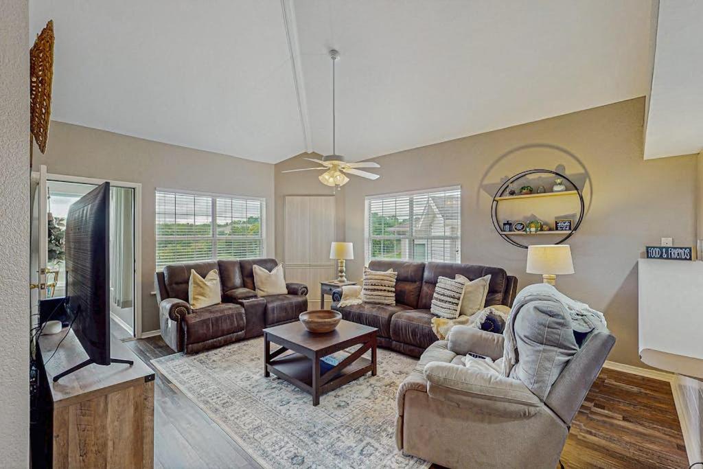 a living room with couches and a flat screen tv at On the Green in Branson