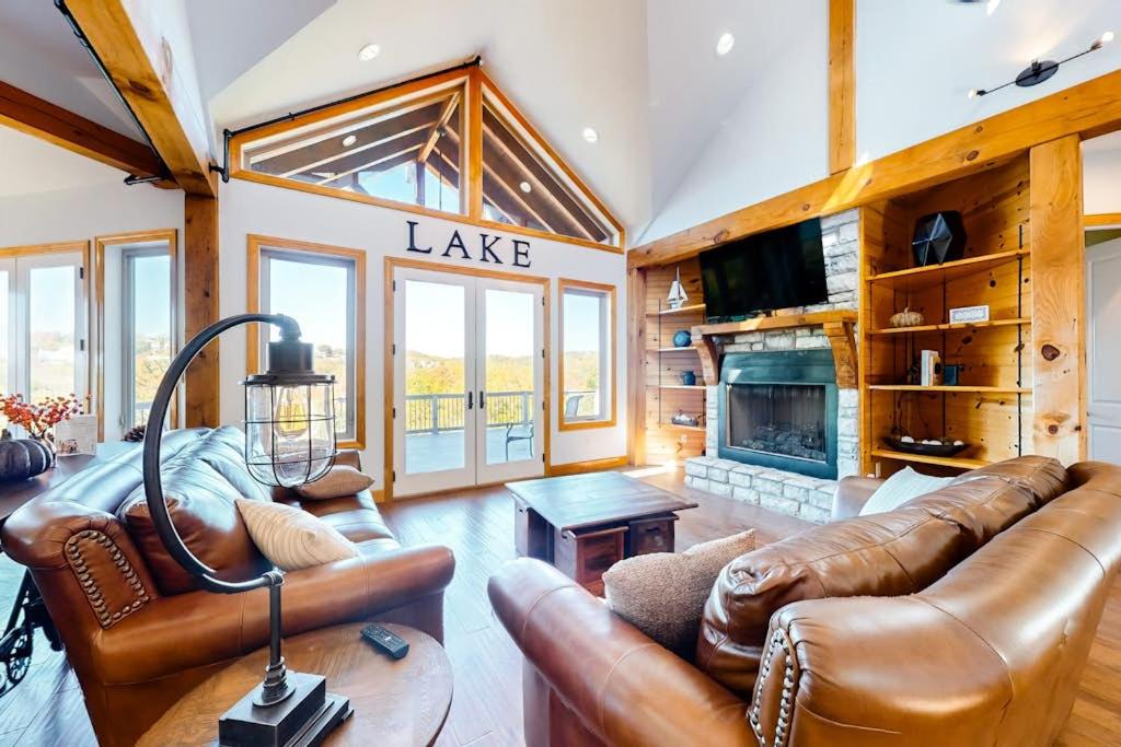 a living room with leather furniture and a fireplace at Treetop View Sanctuary in Branson
