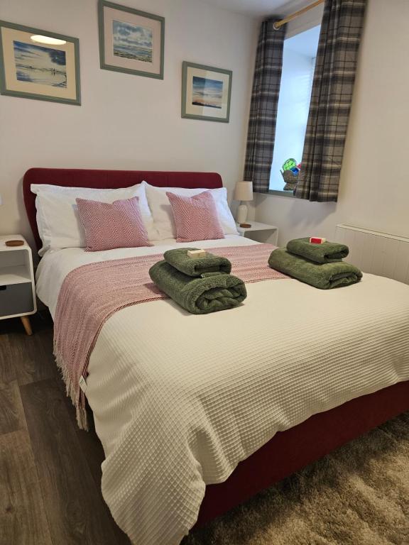 a bedroom with a bed with two green towels on it at Kirkwall Flat 1 in Orkney