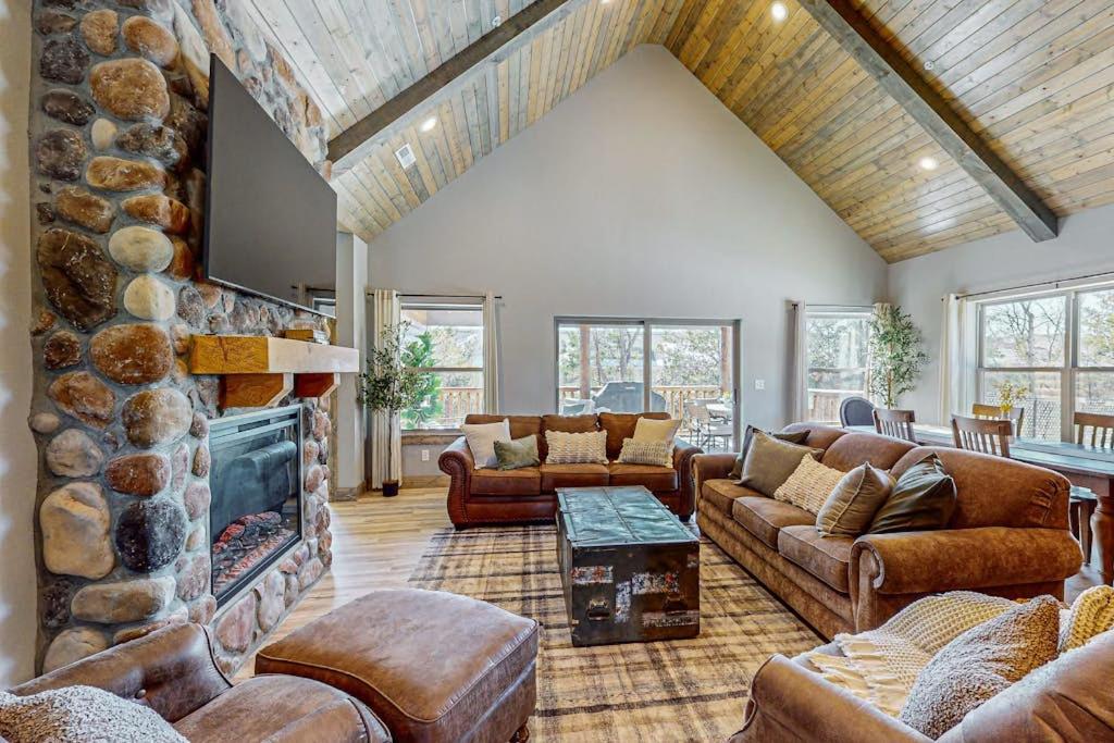 a living room with couches and a stone fireplace at Cozy Cove Lodge in Branson