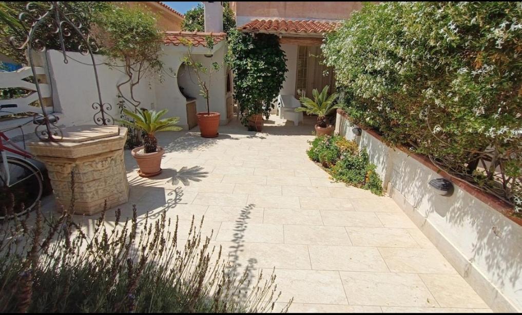 a courtyard with potted plants and a building at Villetta Marausa - Birgi KITE in Marausa