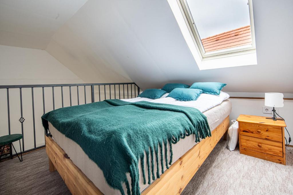 a bedroom with a large bed with blue pillows at Red Stone in Kővágóörs
