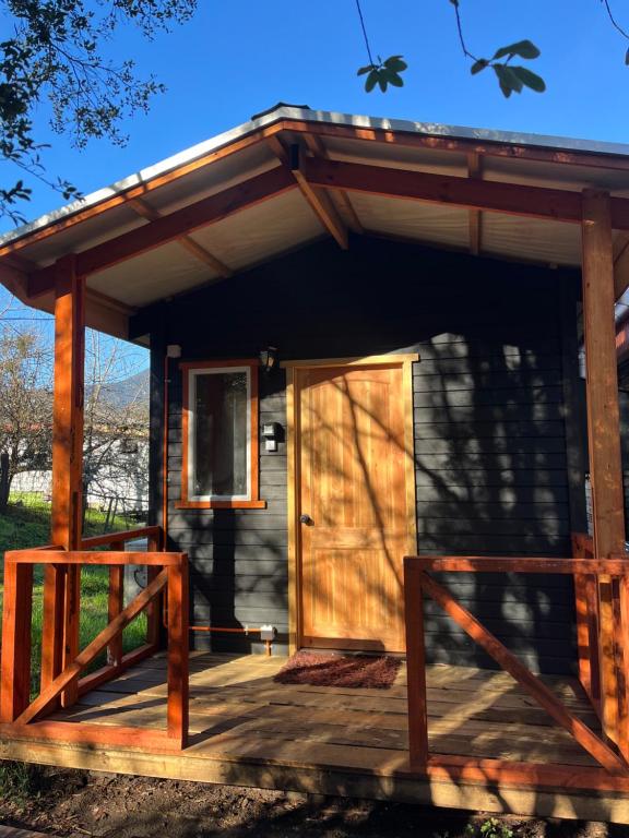 a small cabin with a wooden door on a deck at Cabañas Villegas C2 in Hornopiren