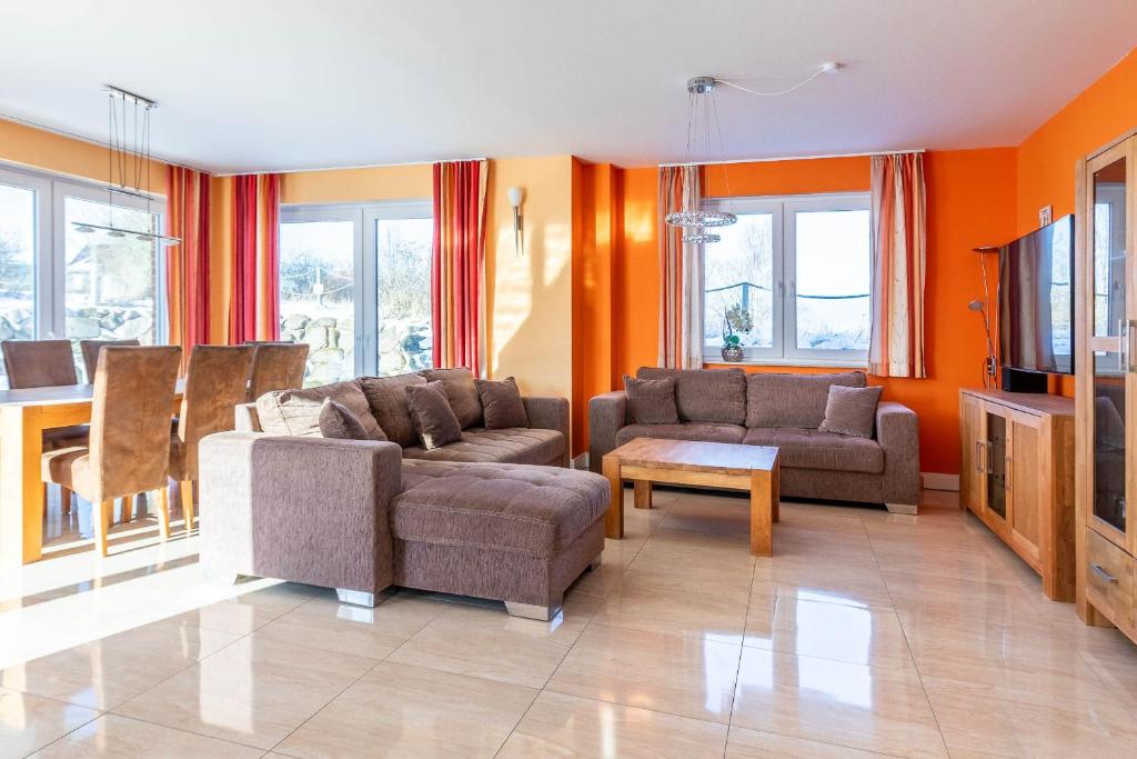 a living room with two couches and a tv at Villa Strandoase in Wohlenberg