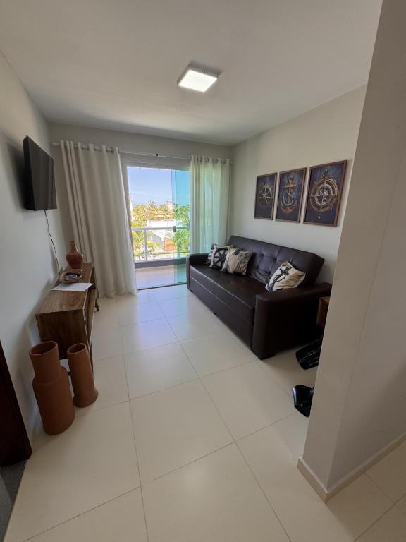 a living room with a couch and a large window at Refúgio Cachoeira Guaibim in Guaibim