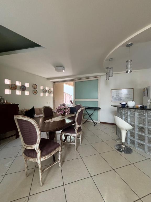 a dining room with a table and chairs in a room at Refúgio Aconchegante com Varanda para Natureza in Resende