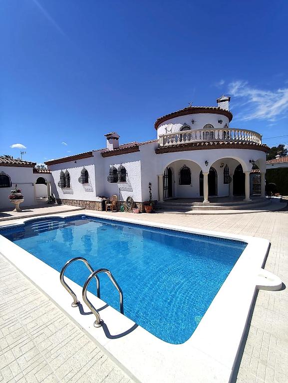 a large house with a swimming pool in front of it at villa PLAYA RUSTICAL in Miami Platja