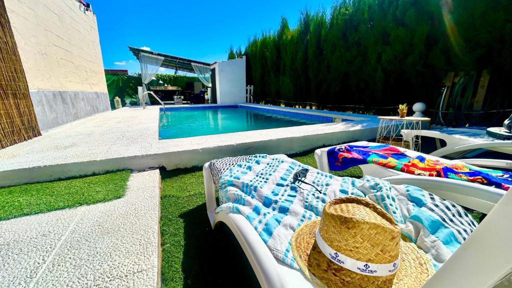 a pool with chaise lounge chairs and a swimming pool at Marife Home in Guillena