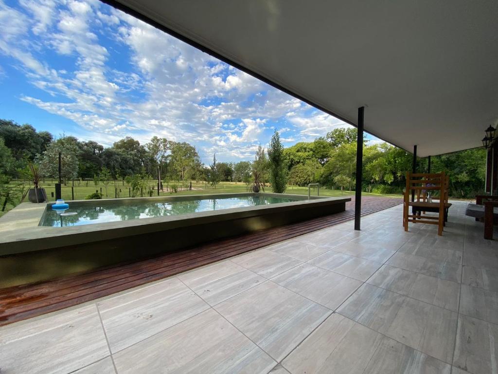 a swimming pool in a house with a large window at Las Marukas casas con pileta in San Antonio de Areco
