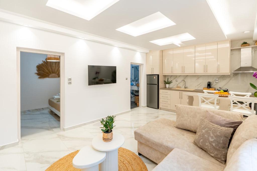 a living room with a couch and a kitchen at Meraki Home in Lixouri