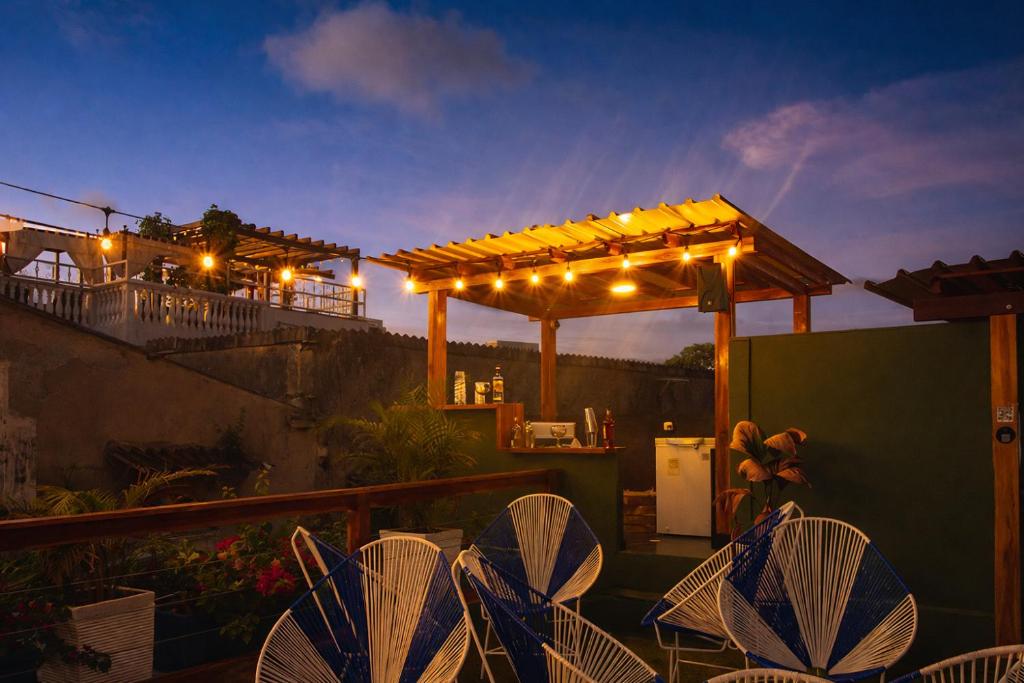 a patio with chairs and a pergola at night at Seven Nights Hostel Cartagena in Cartagena de Indias