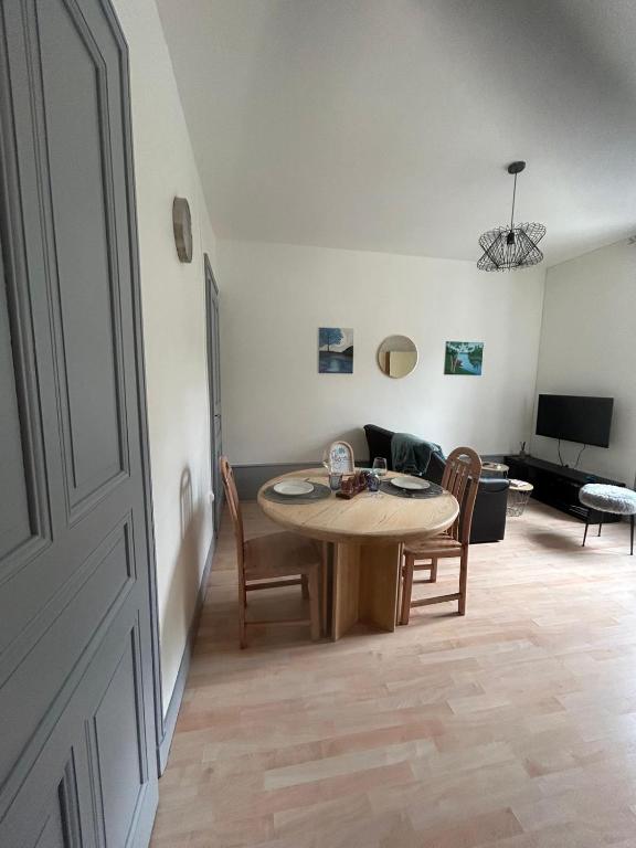 a living room with a table and a couch at L azur Jurassien séjour chaleureux dans le Jura in Saint-Claude