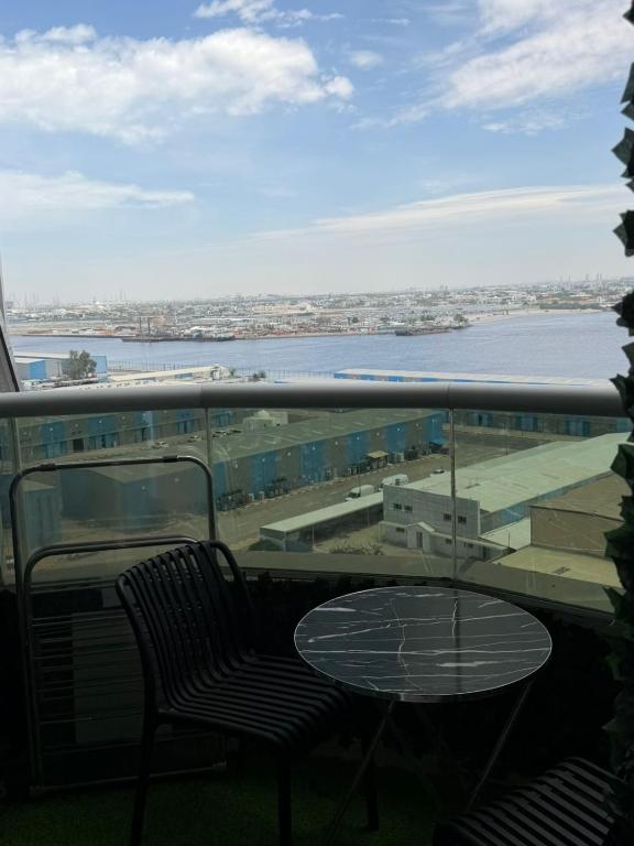 a balcony with a table and a view of the water at High-floor Luxury Apartment! in Ajman 