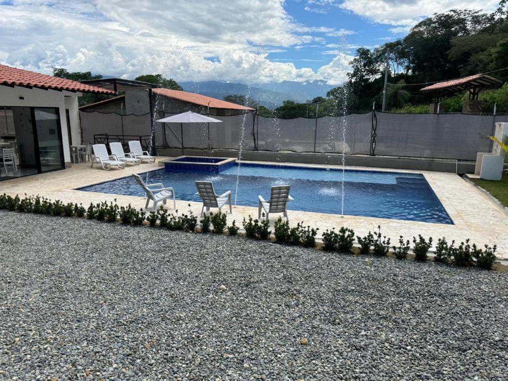 a swimming pool with chairs and a water fountain at Villa Alma in Medellín