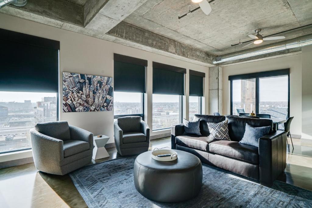a living room with couches and a table and windows at Sable 901 - Penthouse in Minneapolis