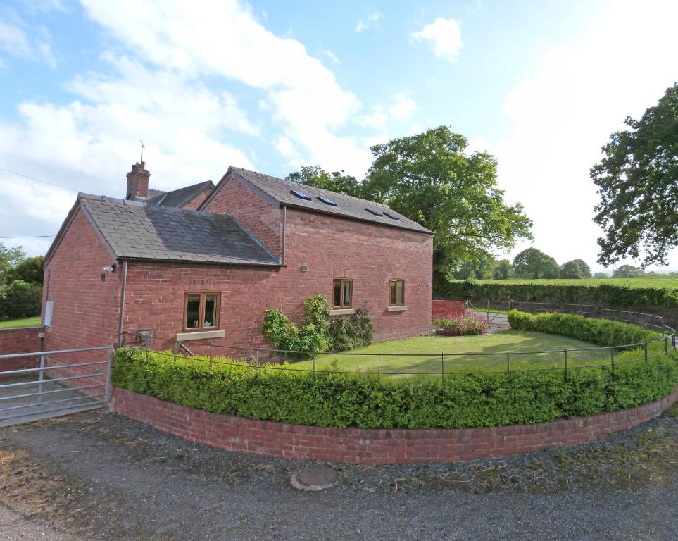 een rood bakstenen huis met een hek eromheen bij 2 Bed in Wrexham oc-26687 in Wynnstay