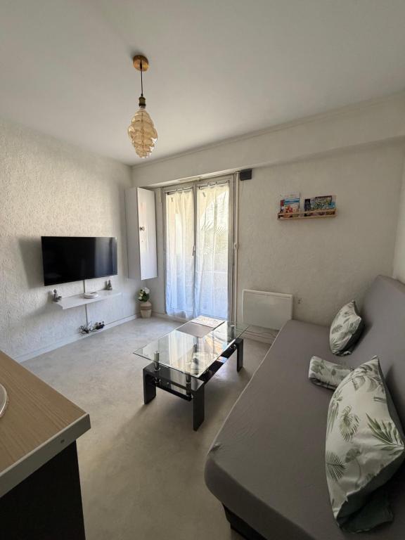 a living room with a couch and a table at Joli studio avec parking privé in Moulins