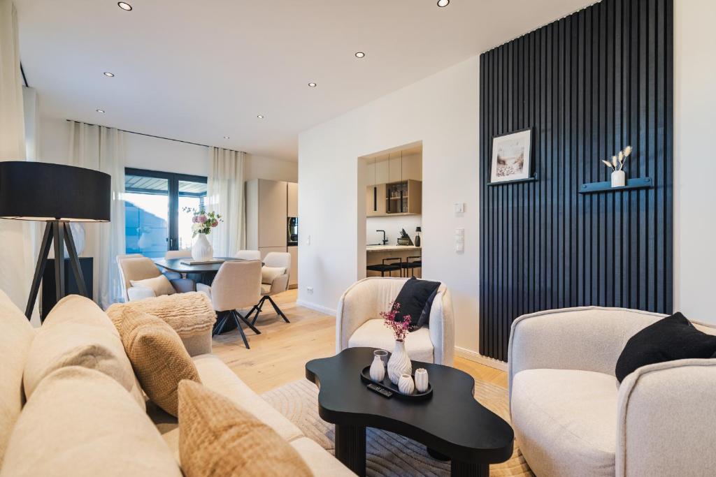 a living room with a couch and chairs and a table at Strandgeflüster deluxe in Zingst