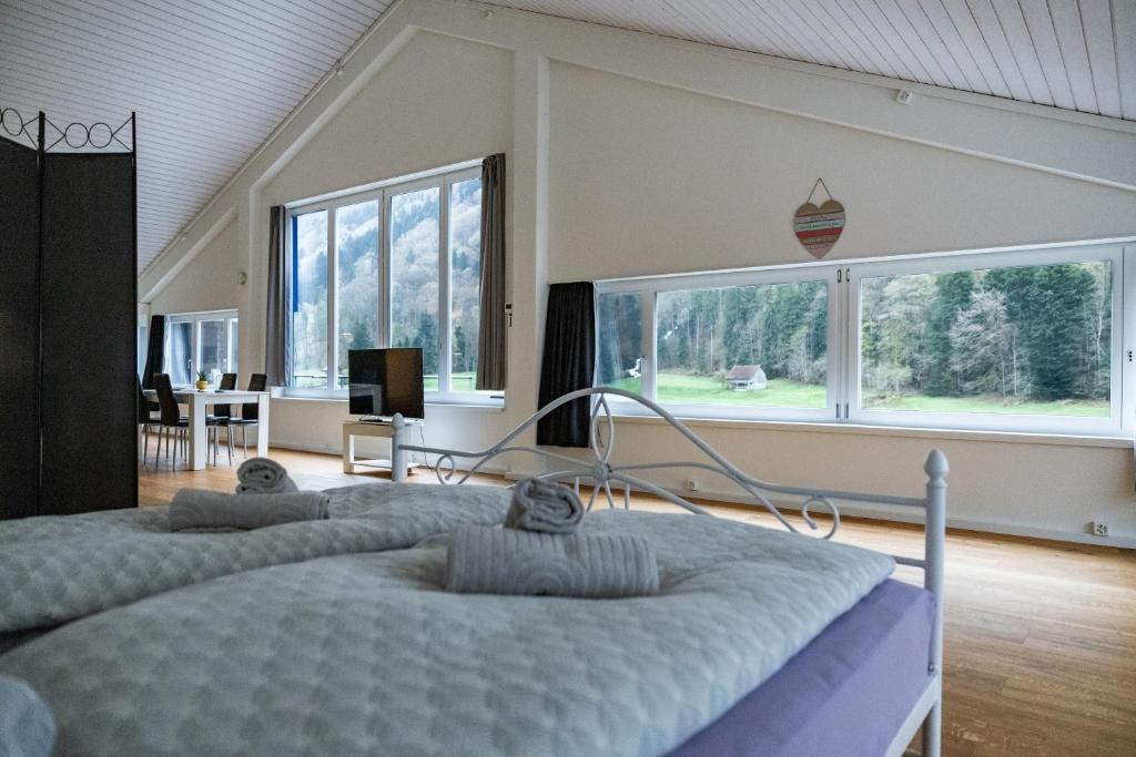 a bedroom with two beds and a large window at Muota River Loft & Muota Industry Apartment near Stoos in Muotathal