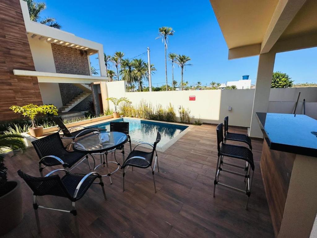 a patio with a table and chairs and a pool at Ap barra grande com piscina in Marau