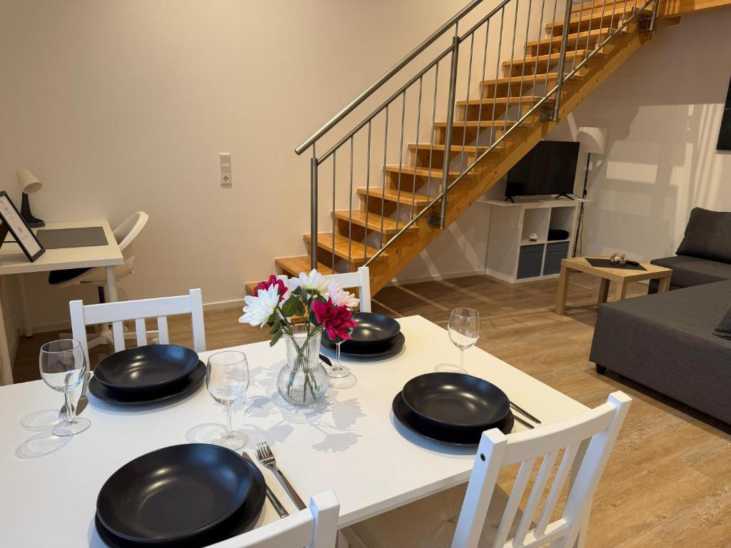 a dining room table with black plates and flowers on it at SchwalbenNest Pfeifers OdenwaldNest in Rimbach