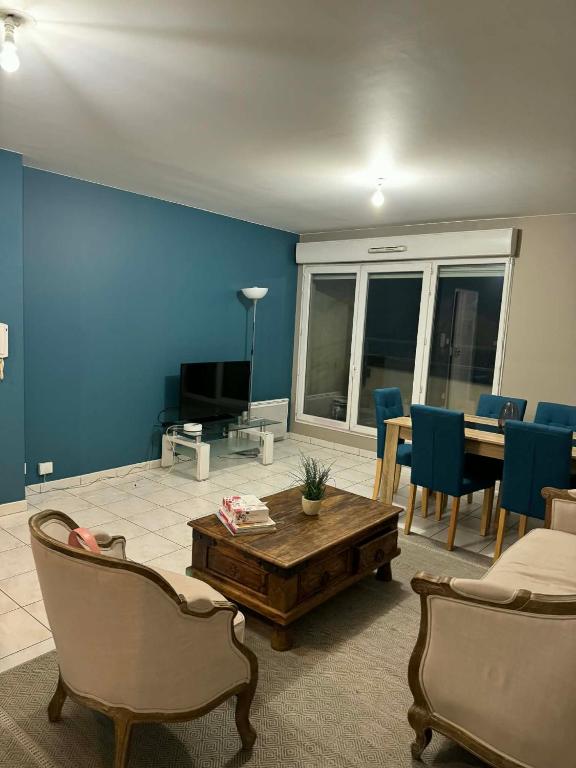 a living room with blue walls and a table and chairs at Apt Parisien in Vitry-sur-Seine
