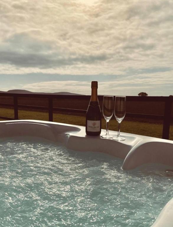 a bottle of wine and two glasses in a hot tub at Middleton Cottages in Yarm