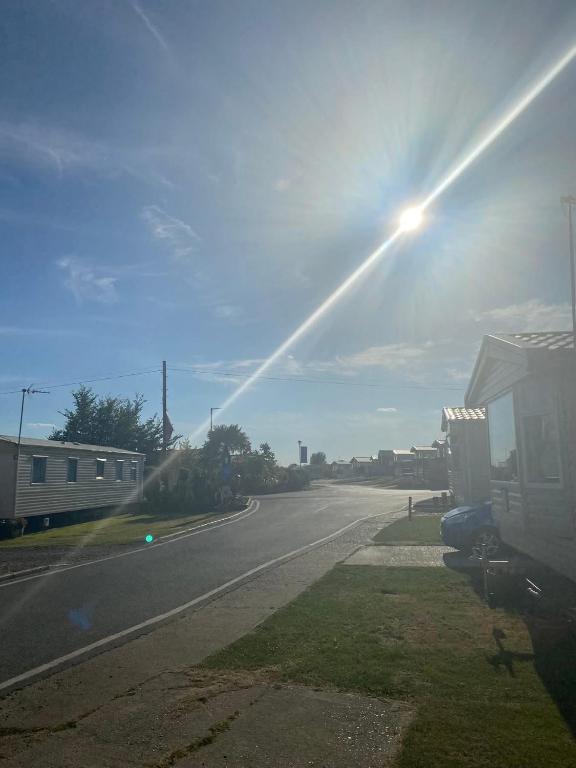 an empty road with the sun shining in the sky at Paddocks 4 in East Mersea