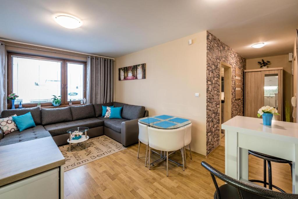 a living room with a couch and a table at Apartman Elegance in Liptovský Mikuláš