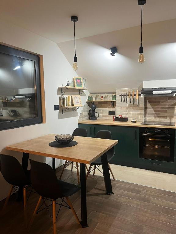 a kitchen with a wooden table and some chairs at Lighthouse Apartman in Svilajnac