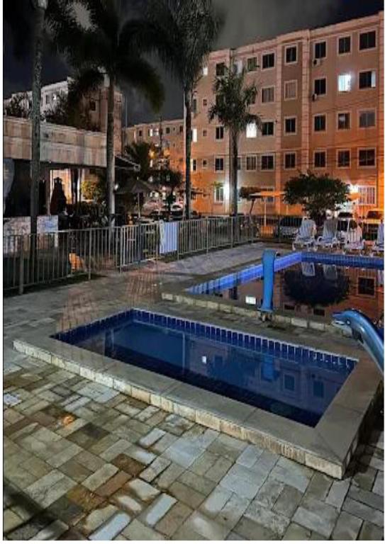 a large swimming pool in a city at night at Apartamento no Antares in Maceió