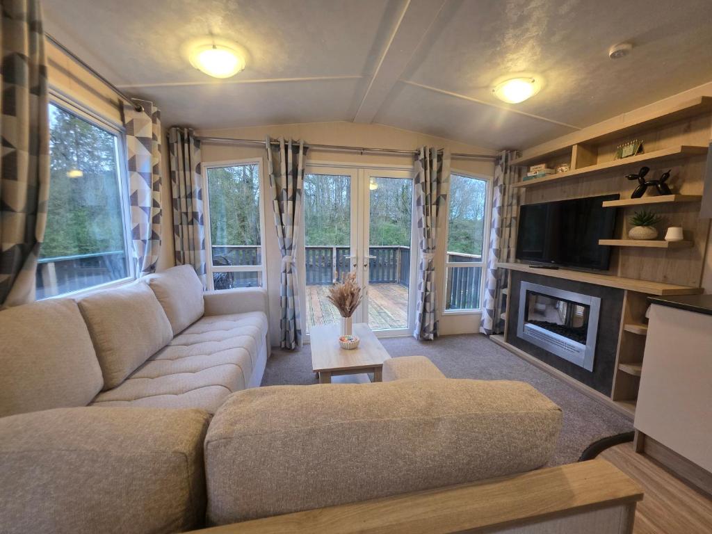 a living room with a couch and a tv at Snug on the Teviot in Hawick
