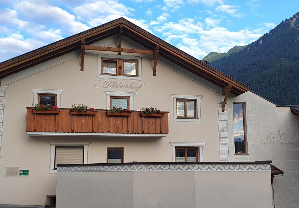 a house with a balcony with flowers on it at Alblerhof in Pfunds