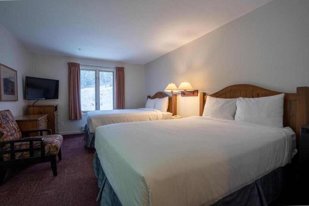 a hotel room with two beds and a television at Cahilty #211 home in Sun Peaks