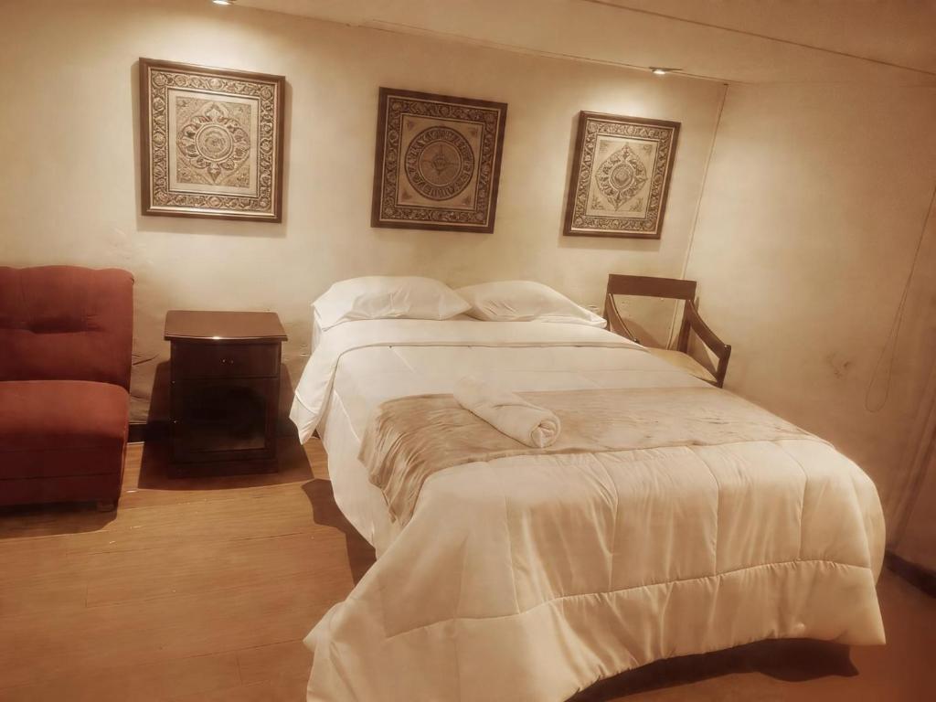 a bedroom with two beds and a chair at Casona Kolivri in Arequipa
