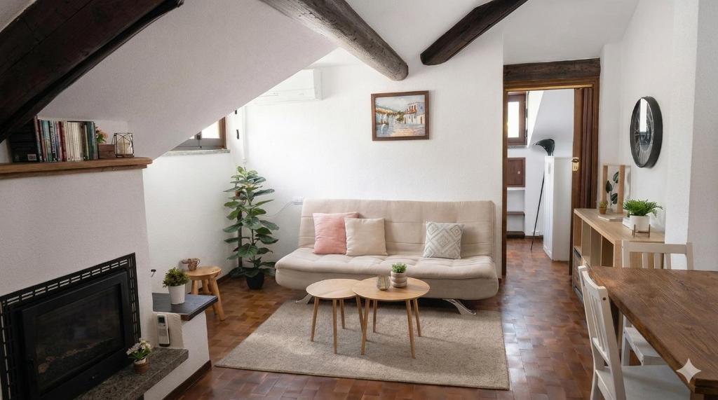 a living room with a couch and a table at Mansarda in centro Menaggio con spiaggia privata e possibilità garage in Menaggio