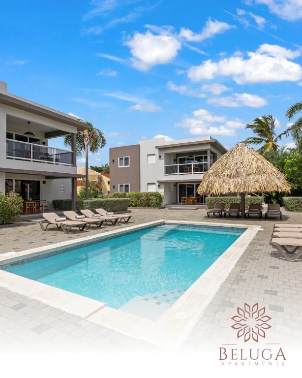 a villa with a swimming pool and a building at Beluga Apartments Curacao - nabij Willemstad & Mambo Beach in Willemstad