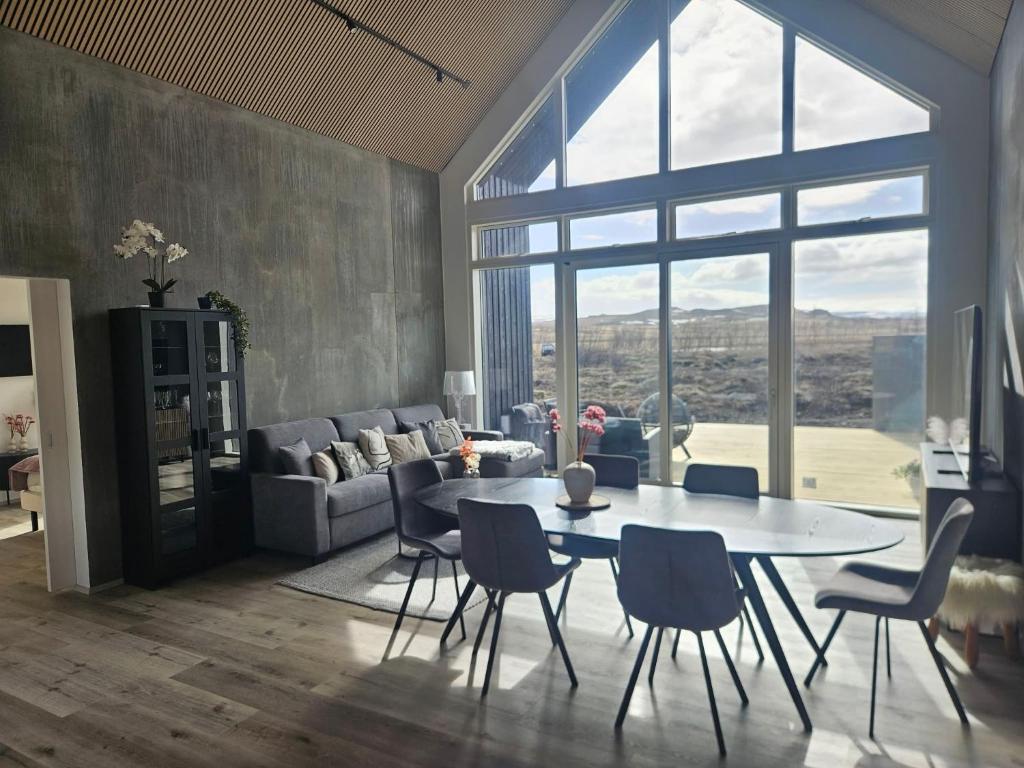 a living room with a table and chairs and a couch at Aurora luxury villa in Reykholt