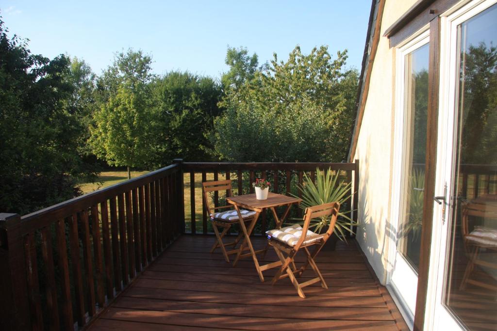 a patio with a table and chairs on a deck at Les Bouts de Rallé Chambre d&#39;Hotes in Sainte-Osmane